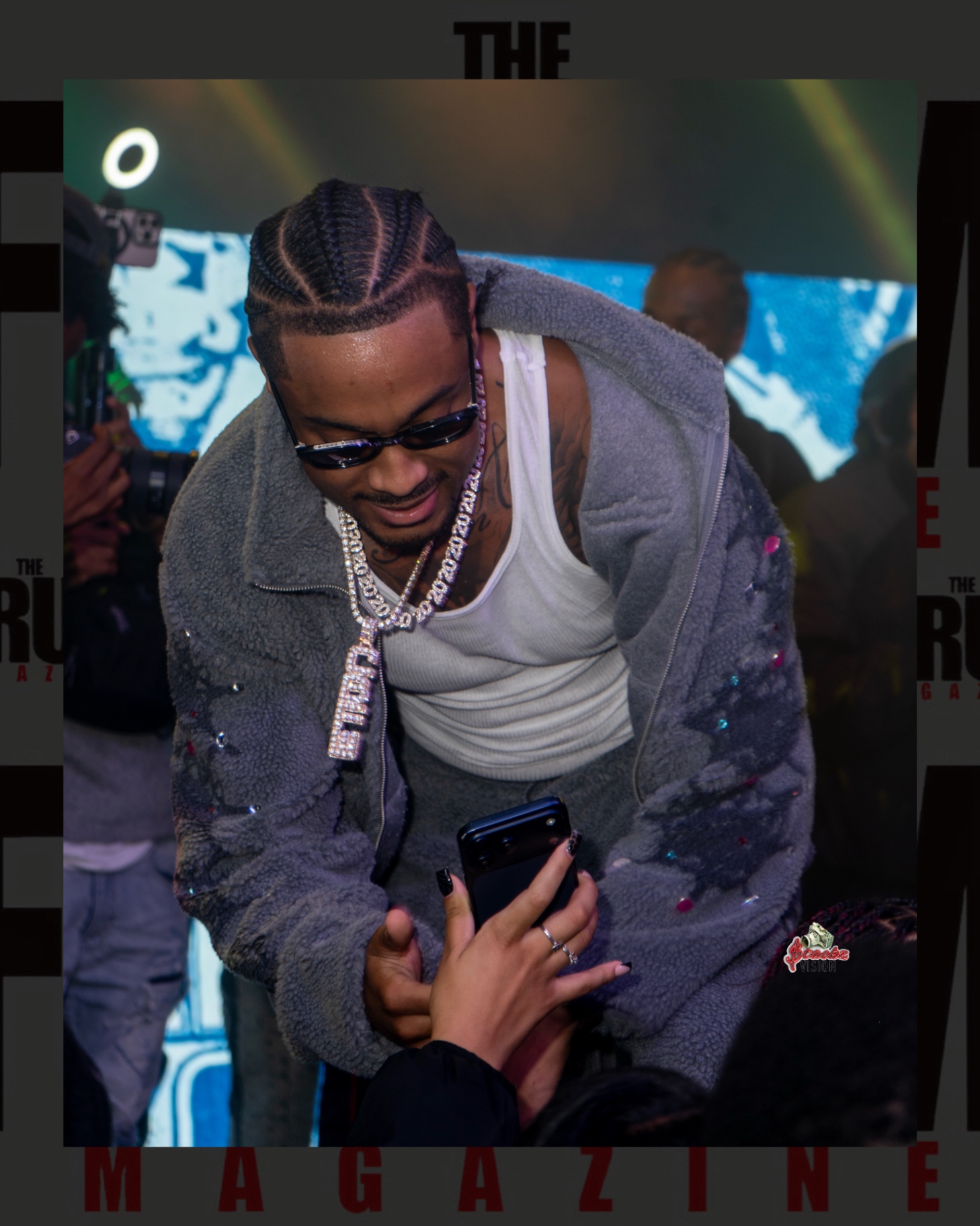 An artist leaning toward a fan holding up a phone during the show